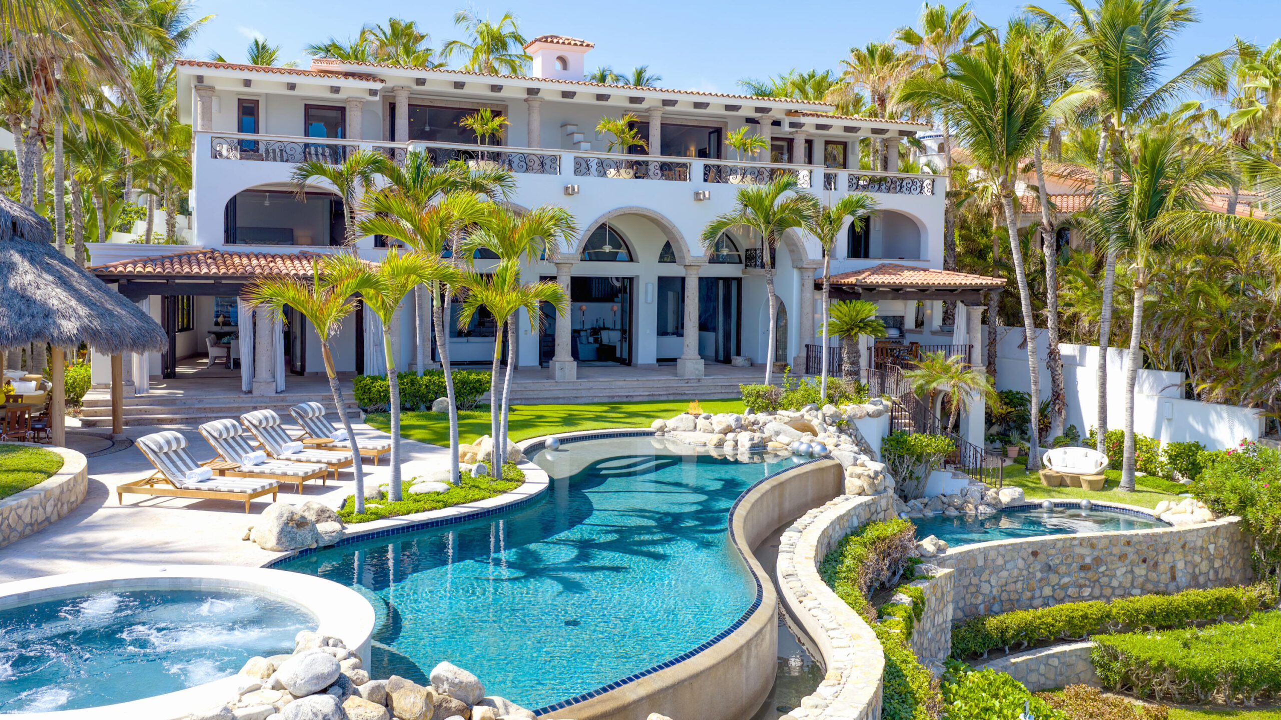 Cabo Luxury La Caleta A once-in-a-generation legacy estate, never before on the market, this iconic beachfront residence offers incomparable prestige on the sands of Palmilla Bay, one of Cabo's most coveted and swimmable beaches. Set on a rare half-acre parcel directly on the water, the home features six bedrooms, six and a half baths, plus a full attached apartment, all executed in classic Palmilla style with timeless elegance and modern comfort. From the moment you enter, the architecture reveals its intention: a grand foyer flows effortlessly into an open living area and bar, framed by soaring ceilings and vast windows that disappear into the Baja breeze. The interiors dissolve into the outdoors, unveiling a dramatic terrace that cascades to a manicured lawn, infinity-edged pool, waterslide, spa, and expansive entertaining pavilion designed for unforgettable gatherings beneath the stars.The second level hosts two principal suites, each opening to a vast private terrace with sweeping for sale