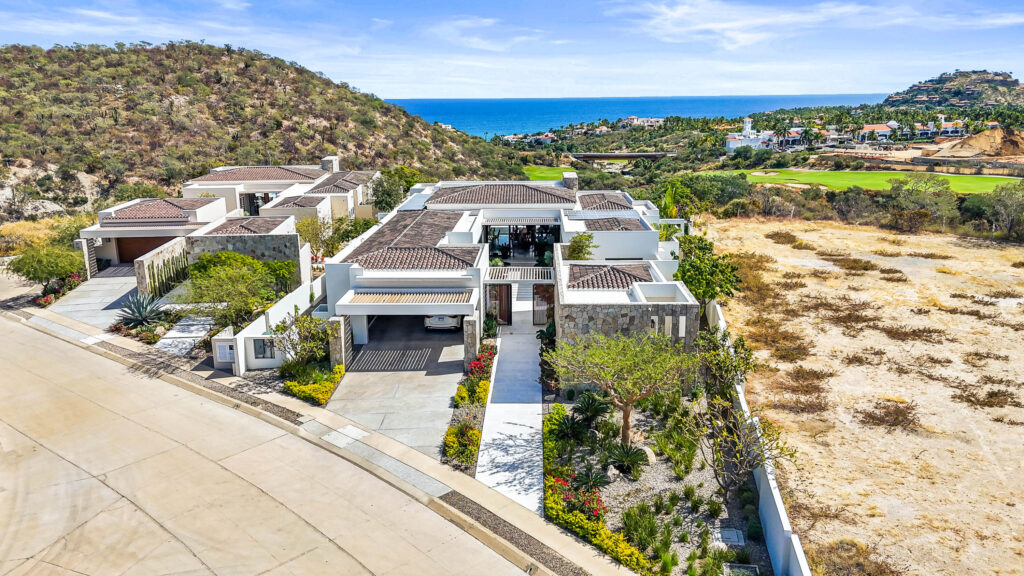 Cabo Luxury Section 18- Horizontes A stunning entry flanked on both sides by art display walls sets the tone for this contemporary masterpiece located in the Private Golf and Beach community of Querencia. Thoughtful architecture helps create a seamless transition from indoor to outdoor spaces complete with a resort style pool, lush landscaping, fire pit plus double sided fireplace, outdoor bar and full pool bath with shower. This beautifully furnished home has 4 bedrooms,6.5 baths which includes a one of a kind master-bedroom suite with his and her baths and a designers dream closet that could easily convert back to the original 5 bedroom floor plan. Completed in 2023, this almost new smart home features the latest technology and top of the line appliances, plus a full house solar system and hurricane shutters. – Querencia, Casa 9 at Horizontes, San Jose Corridor, San Jose Corridor, BS